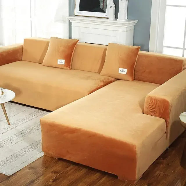 Luxury gold velvet sectional sofa with plush throw pillows in a modern living room setting.