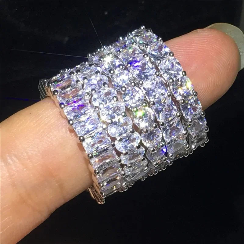 Eye-catching silver eternity bands with sparkling gemstones on a finger, radiating unique style.