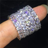 Eye-catching silver eternity bands with sparkling gemstones on a finger, radiating unique style.