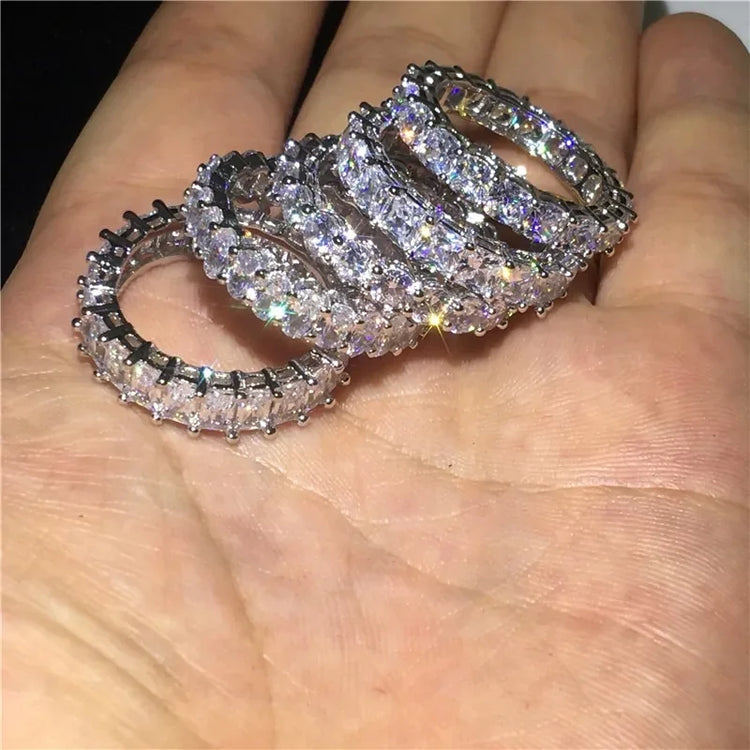 Sparkling eternity bands with brilliant stones, catching the light in an open palm, inviting curiosity.