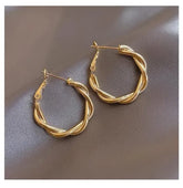 Intriguing twisted gold hoop earrings on satin, unique statement jewelry for stylish looks