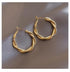 Intriguing twisted gold hoop earrings on satin, unique statement jewelry for stylish looks