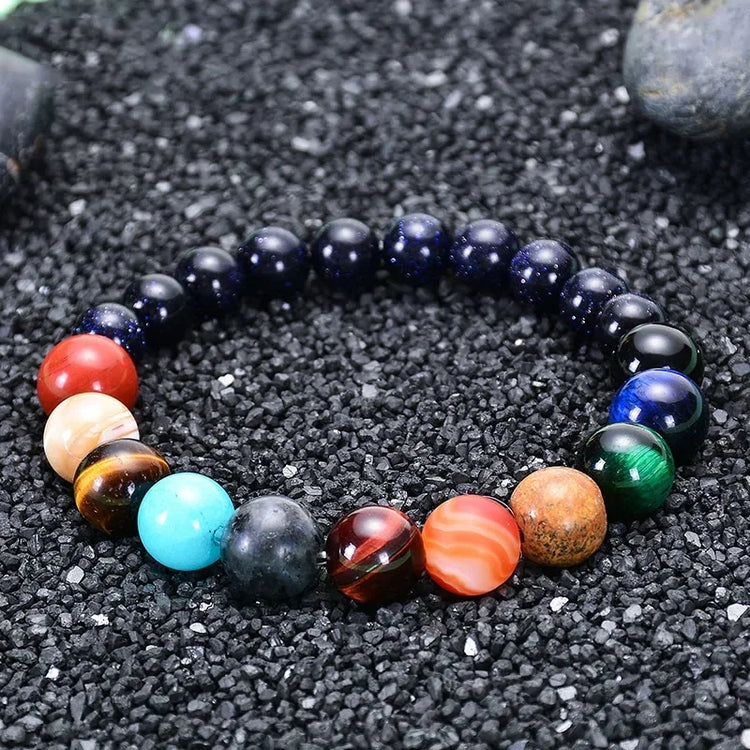 Intriguing multicolor gemstone beaded bracelet on black gravel, expressing bold unique style