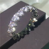 Sparkling eternity band with dazzling heart-shaped stones, perfect for unique, stylish looks.
