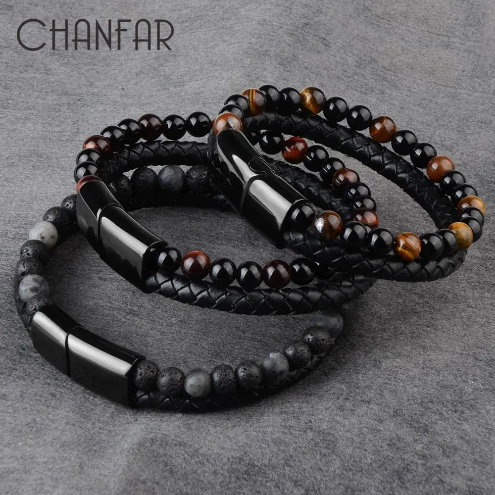 Set of stylish beaded and braided leather bracelets with glossy black clasps on grey fabric