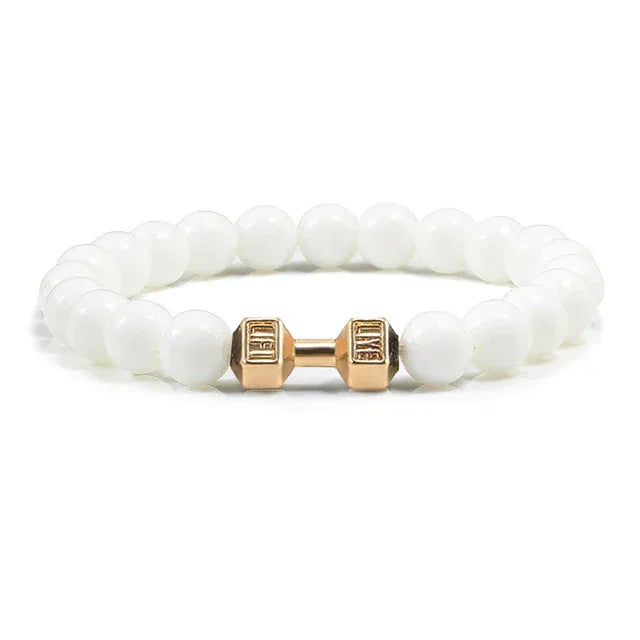Elegant white beaded bracelet with unique gold dumbbell charm, perfect for standout jewelry style