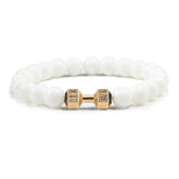 Elegant white beaded bracelet with unique gold dumbbell charm, perfect for standout jewelry style
