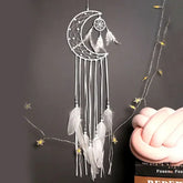 Unique crescent moon dreamcatcher with white feathers and beads, perfect for stylish wall decor.