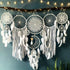 Intricate white dreamcatcher wall décor with feathers and lights, creating a unique boho vibe.