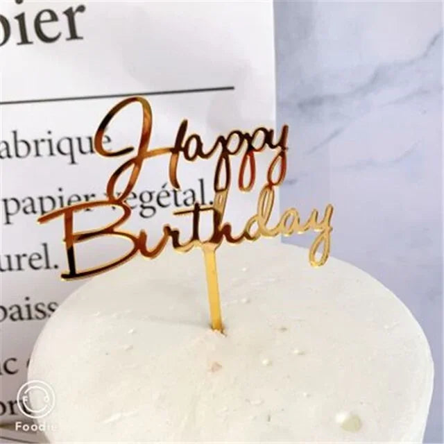 Elegant gold Happy Birthday cake topper on minimalist white frosted cake, perfect for unique celebrations