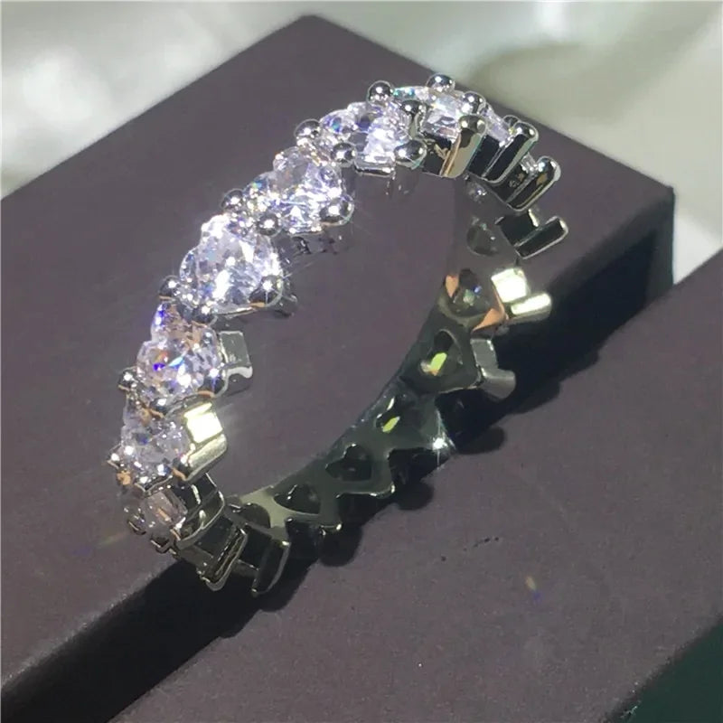 Dazzling silver eternity ring with sparkling round stones and heart-shaped details, a unique statement piece
