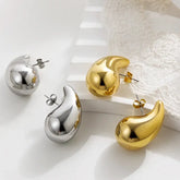 Eye-catching gold and silver abstract stud earrings on white background, modern unique jewelry