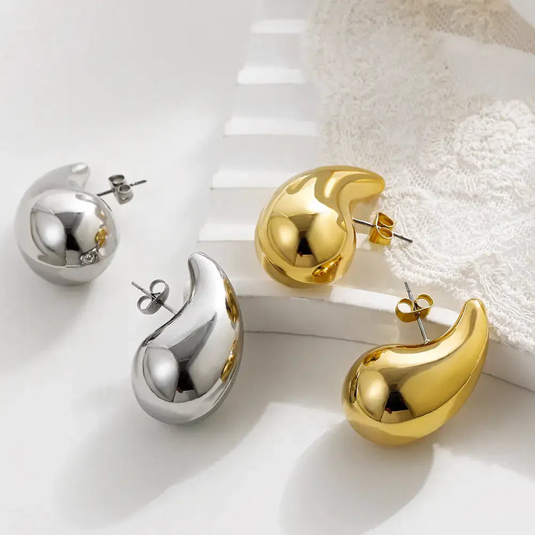 Eye-catching gold and silver abstract stud earrings on white background, modern unique jewelry