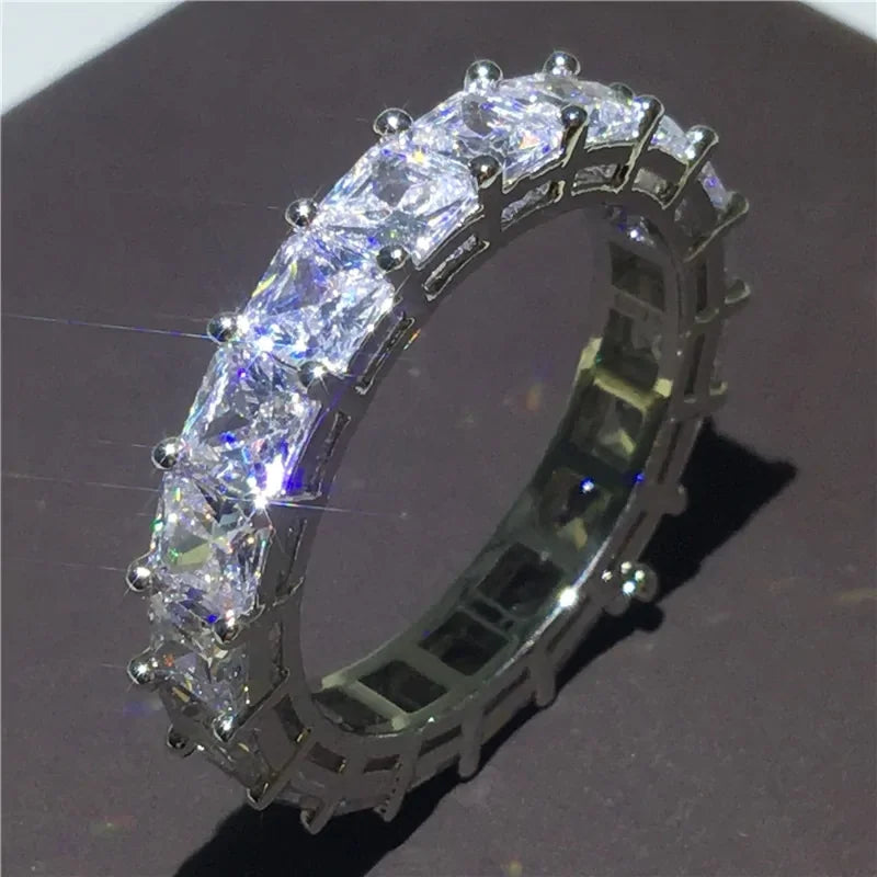 Dazzling silver eternity ring with radiant square-cut stones, sparkling with unique brilliance.
