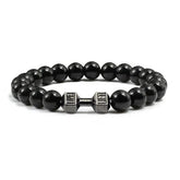 Bold black beaded bracelet with unique silver dumbbell charm, a standout accessory for fitness fans.