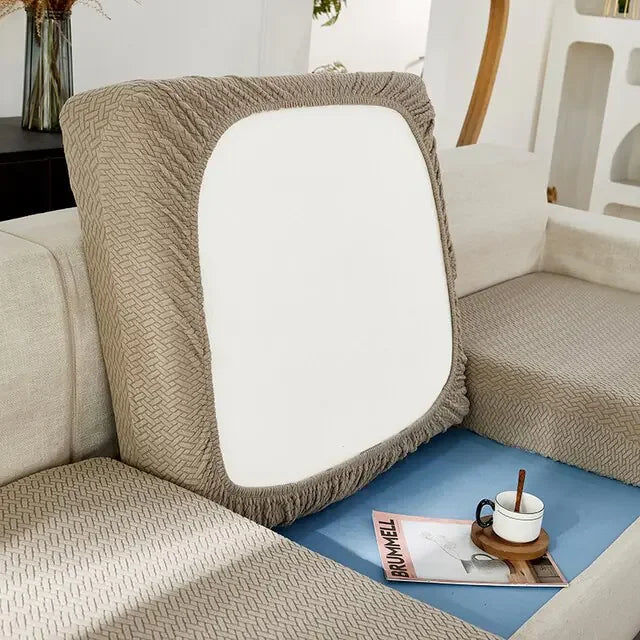 Modern beige sofa with unique geometric-patterned cushion, cozy home décor accent