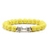 Bright yellow beaded bracelet with unique silver dumbbell charm, perfect for bold jewelry lovers