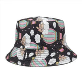 Whimsical bucket hat with pastel hot air balloons, cute dogs, and clouds on a black background.