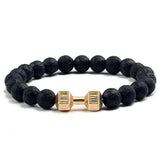 Bold black lava bead bracelet with a unique gold dumbbell charm, perfect for standout style.