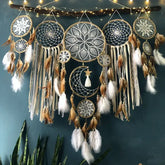 Boho wall décor with intricate dreamcatchers, feathers, lace, and moon design for unique home style