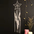 Enchant your space with a star-shaped dreamcatcher, white feathers, and cozy string lights.