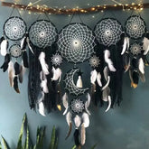 Enchanting black and white dreamcatcher wall decor with feathers, moon motif, and string lights