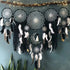 Enchanting black and white dreamcatcher wall decor with feathers, moon motif, and string lights