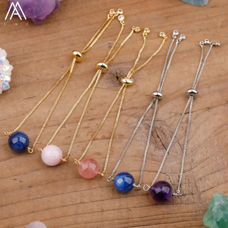 Elegant gemstone bead adjustable chain bracelets in gold and silver on a rustic wooden table.