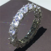 Dazzling eternity band with sparkling round-cut stones set in silver, catching the light beautifully.