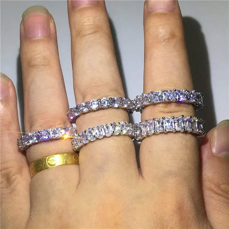 Elegant silver eternity bands with sparkling cubic zirconia on hand, eye-catching and unique.