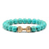 Vivid turquoise beaded bracelet with unique gold dumbbell accent, perfect for standout style.
