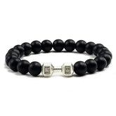 Bold matte black beaded bracelet with silver dumbbell charm, perfect for unique style seekers.