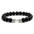 Bold matte black beaded bracelet with silver dumbbell charm, perfect for unique style seekers.