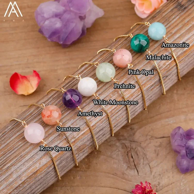 Colorful gemstone drop earrings set on wood, featuring rose quartz, amethyst, sunstone, and more—discover your distinct style.