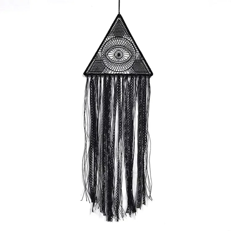 Intriguing black triangle macrame wall hanging with eye motif and flowing textured fringe, perfect for unique home décor.
