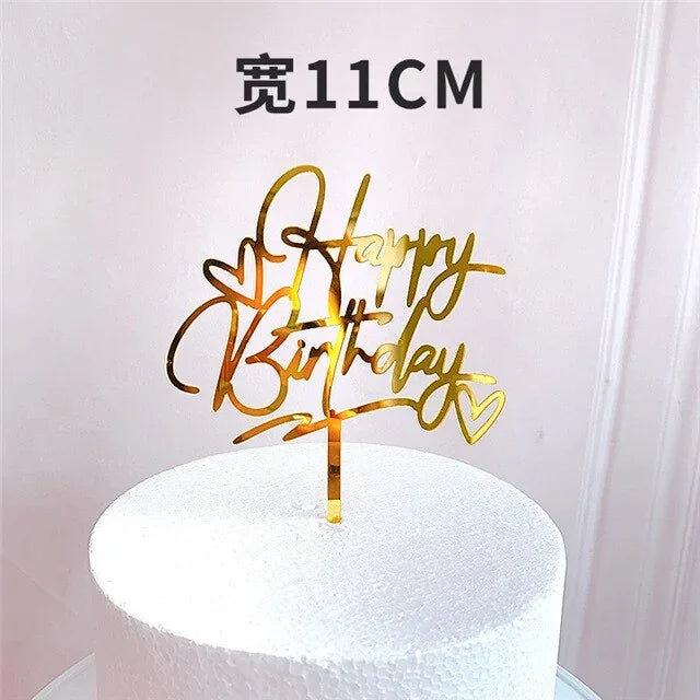 Gold acrylic Happy Birthday cake topper with heart accents, 11cm wide, on a white cake