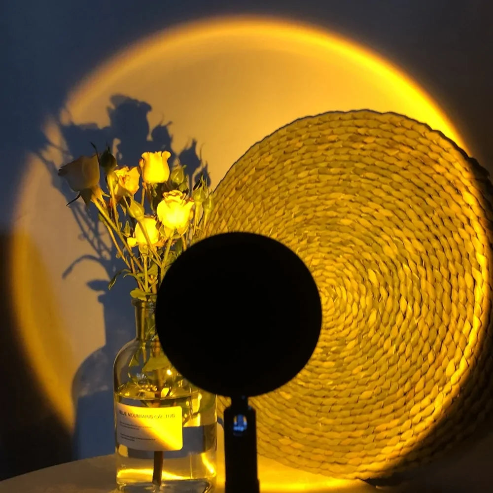 Warm sunset projector lamp casting golden light on woven décor and roses in glass vase