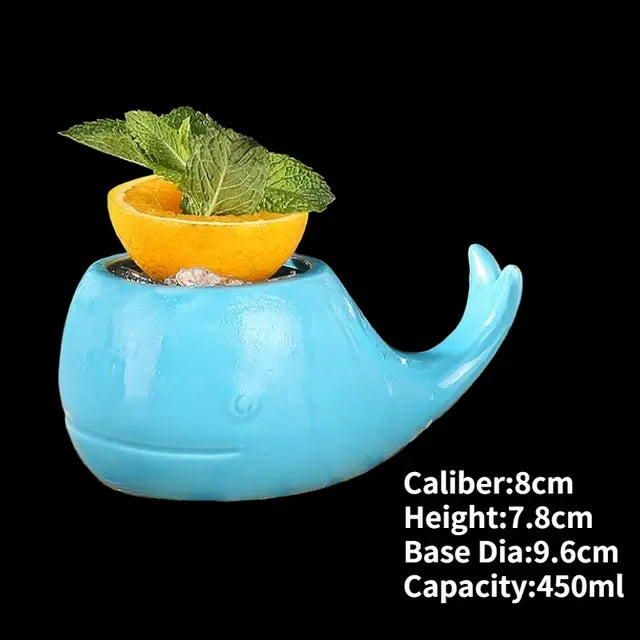 Charming blue whale-shaped ceramic mug with citrus and mint garnish, unique décor accent