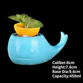 Charming blue whale-shaped ceramic mug with citrus and mint garnish, unique décor accent