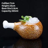 Curious ceramic mug shaped like a chicken drumstick, filled with ice and mint, unique home décor