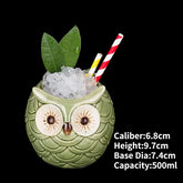 Charming owl-shaped ceramic cup with ice, leaves, and striped straws, perfect for unique décor.